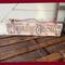 A handmade Christmas sign. Old time writing has been wood-burned onto a piece of reclaimed wood. Reindeer and holly are on either side. 